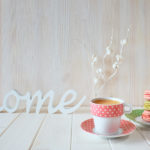 Spring coffee background. The word “Home” made of wood, white pa